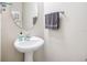 Simple powder room featuring a pedestal sink, round mirror, and a towel rack at 1027 Banks Rose St, Celebration, FL 34747