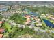 Aerial view of a home in a beautiful community with tree lined streets, lush greenery, and community ponds at 1233 Cambria Bnd, Kissimmee, FL 34759