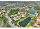 Expansive aerial view of a residential area with several small lakes and lush greenery, with roof highlighted in red at 1233 Cambria Bnd, Kissimmee, FL 34759