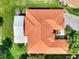 Birds eye view of a lovely home with a red tile roof, meticulously maintained landscaping, and a screened in lanai at 1233 Cambria Bnd, Kissimmee, FL 34759