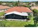 An aerial view of the backyard featuring a screened in lanai, lush landscaping, and exterior patio at 1233 Cambria Bnd, Kissimmee, FL 34759