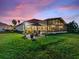 Spacious backyard featuring a screened patio and beautiful twilight sky at 1233 Cambria Bnd, Kissimmee, FL 34759