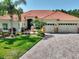 Beautiful home featuring a tile roof, manicured lawn, and a paver driveway leading to a two-car garage at 1233 Cambria Bnd, Kissimmee, FL 34759