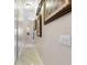 Long hallway with neutral paint, a cream tiled floor, art on the walls, and accent lighting at 1233 Cambria Bnd, Kissimmee, FL 34759