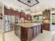 Gourmet kitchen featuring an island with wine storage, stainless steel appliances, and granite countertops at 1233 Cambria Bnd, Kissimmee, FL 34759