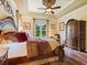 Bright main bedroom boasts trey ceilings, a ceiling fan, and views of the landscaped yard at 1233 Cambria Bnd, Kissimmee, FL 34759