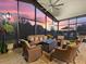 Relaxing outdoor seating area with a beautiful view of a sunset through the screened windows at 1233 Cambria Bnd, Kissimmee, FL 34759