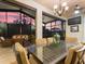Covered patio area features an outdoor dining table and sitting area with a sunset view through screened windows at 1233 Cambria Bnd, Kissimmee, FL 34759