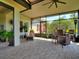 Relaxing outdoor patio featuring stylish tile flooring, comfortable seating, and beautiful garden views at 1233 Cambria Bnd, Kissimmee, FL 34759