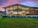 Covered patio featuring expansive glass walls, offering seamless indoor-outdoor living and serene backyard views at 1233 Cambria Bnd, Kissimmee, FL 34759