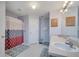 Bathroom with dual sinks, large mirror, and shower with patterned curtain at 1437 Swift Ct, Kissimmee, FL 34759