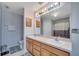 Well-lit bathroom featuring a double vanity, large mirror, and a shower with a decorative curtain at 1437 Swift Ct, Kissimmee, FL 34759