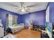 A bedroom with blue walls, hardwood floors, a ceiling fan, and a window at 1437 Swift Ct, Kissimmee, FL 34759