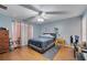 Bedroom featuring wood floors, a ceiling fan, a bed with a blue comforter, and natural light at 1437 Swift Ct, Kissimmee, FL 34759