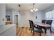 Open dining space with wood flooring, view into kitchen, and a nearby doorway at 1437 Swift Ct, Kissimmee, FL 34759
