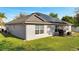 Exterior view of home featuring solar panels, a well-maintained lawn, and a patio with a barbecue grill at 1437 Swift Ct, Kissimmee, FL 34759