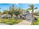 Well-kept single-story home with lush green lawn and mature trees, complemented by solar panels at 1437 Swift Ct, Kissimmee, FL 34759