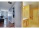 Hallway view towards front door and a yellow bathroom with a single sink at 1437 Swift Ct, Kissimmee, FL 34759