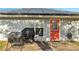 View of the rear of house with solar panels, red door, and outdoor grill on the concrete patio at 1437 Swift Ct, Kissimmee, FL 34759