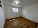 Bright bedroom featuring updated flooring, a single window, and freshly painted white walls at 1749 Sorolla Ct, Orlando, FL 32811