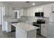 Bright kitchen with white cabinets, stainless steel appliances, and an island at 1749 Sorolla Ct, Orlando, FL 32811