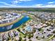 An aerial view of a community with a lake, pools, and amenities surrounded by lush greenery and homes at 2569 Reading Trl, Kissimmee, FL 34746