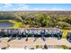 Aerial view of townhomes with lush landscaping, parking, and a serene wooded backdrop at 2569 Reading Trl, Kissimmee, FL 34746