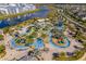An aerial view of a pool and lazy river, with a lake in the background at 2569 Reading Trl, Kissimmee, FL 34746