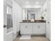 Bathroom featuring a double vanity, shower with curtain, and decorative wall art at 2569 Reading Trl, Kissimmee, FL 34746