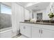 Bathroom featuring a double vanity, shower with curtain, and natural light at 2569 Reading Trl, Kissimmee, FL 34746