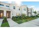 Street-level view of new townhome featuring pristine landscaping, a welcoming entrance, and modern architectural details at 2569 Reading Trl, Kissimmee, FL 34746