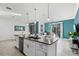 Island kitchen boasting an eat-in island, white cabinets, and contemporary finishes that flows into the living area at 2569 Reading Trl, Kissimmee, FL 34746