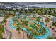 The neighborhood pool area, with a lazy river, mini golf, lounge chairs, and shaded tables at 2569 Reading Trl, Kissimmee, FL 34746