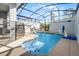 Sparkling screened-in pool with poolside seating and basketball hoop for outdoor fun at 2569 Reading Trl, Kissimmee, FL 34746