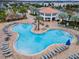 Up close aerial view of resort-style pool, with lounge chairs and tables all around for residents at 2569 Reading Trl, Kissimmee, FL 34746
