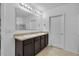 Bathroom with double sinks, dark cabinets, tiled floor, large mirror, and shower in the background at 260 Willow Bend Dr, Davenport, FL 33897