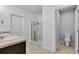 Bright bathroom featuring double sinks, tiled floors, walk-in shower, and adjacent toilet room at 260 Willow Bend Dr, Davenport, FL 33897