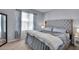 The primary bedroom features a gray upholstered headboard, neutral walls, and large window at 260 Willow Bend Dr, Davenport, FL 33897