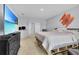 Spacious bedroom with a tropical beach scene playing on a large TV, bright painting on the wall at 260 Willow Bend Dr, Davenport, FL 33897