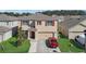 Two-story home with a two-car garage, red shutters, and a well-maintained lawn at 260 Willow Bend Dr, Davenport, FL 33897