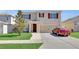 Charming two-story home with a well-maintained lawn and a red car parked in the driveway at 260 Willow Bend Dr, Davenport, FL 33897