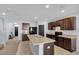 Open kitchen with an island, dark cabinetry, tile flooring, black appliances, and modern fixtures for meal preparation at 260 Willow Bend Dr, Davenport, FL 33897
