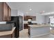 Well-equipped kitchen featuring dark cabinets, an island with a sink, and black appliances providing ample counter space at 260 Willow Bend Dr, Davenport, FL 33897