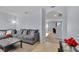 Open living room with neutral walls, plush gray sofa and a glimpse of dining area at 260 Willow Bend Dr, Davenport, FL 33897
