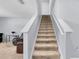 Carpeted stairs lead to the upper level, featuring white risers and handrails, creating a clean transition at 260 Willow Bend Dr, Davenport, FL 33897