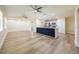 Open-concept kitchen with quartz counters, stainless steel appliances, a kitchen island, and wood-look floors at 2931 Chilton St, Deltona, FL 32738