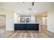 Bright kitchen featuring a large island with a black paneled base, stainless steel appliances, and white cabinets at 2931 Chilton St, Deltona, FL 32738