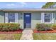 Charming home exterior with a blue front door, updated windows, and landscaped yard at 30 Las Palmas Way, Kissimmee, FL 34743