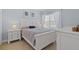 Well-lit bedroom with white furniture, a patterned bedspread, and soft natural light from the window at 3304 Cat Brier Trl, Harmony, FL 34773