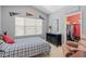Bedroom with sports memorabilia, a blue plaid bedspread, and plenty of natural light streaming through the window at 3304 Cat Brier Trl, Harmony, FL 34773